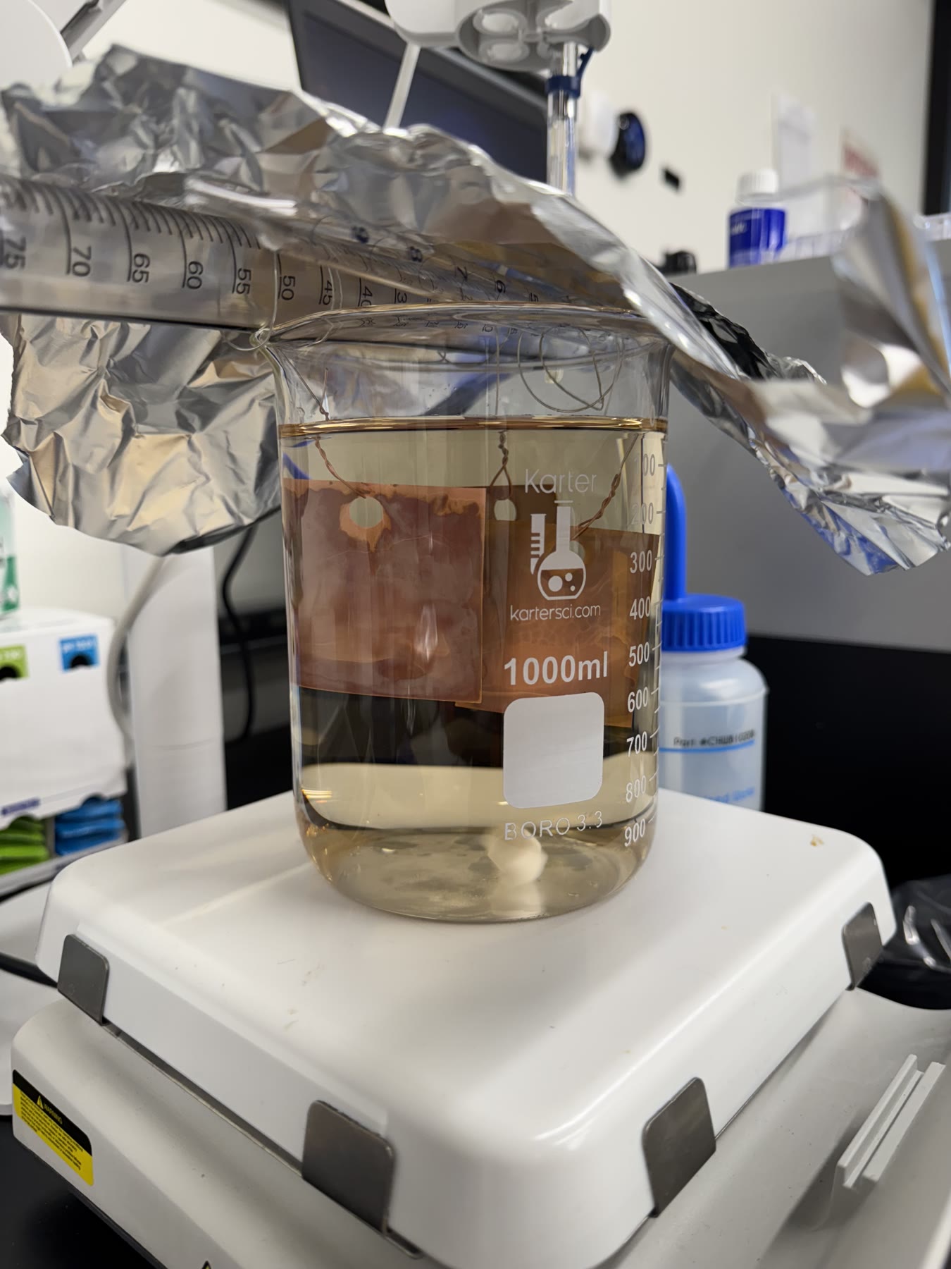 Beaker containing a pale liquid sample on a laboratory stir plate