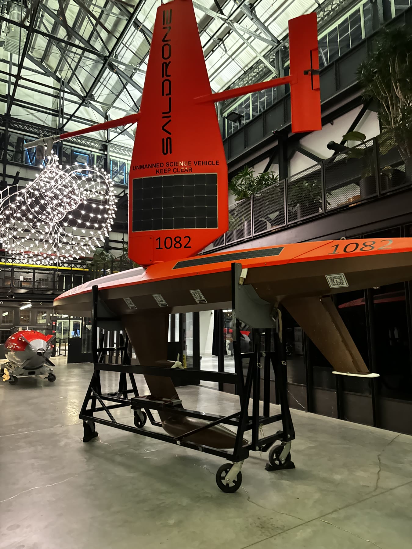 Red Saildrone uncrewed platform displayed inside an industrial facility