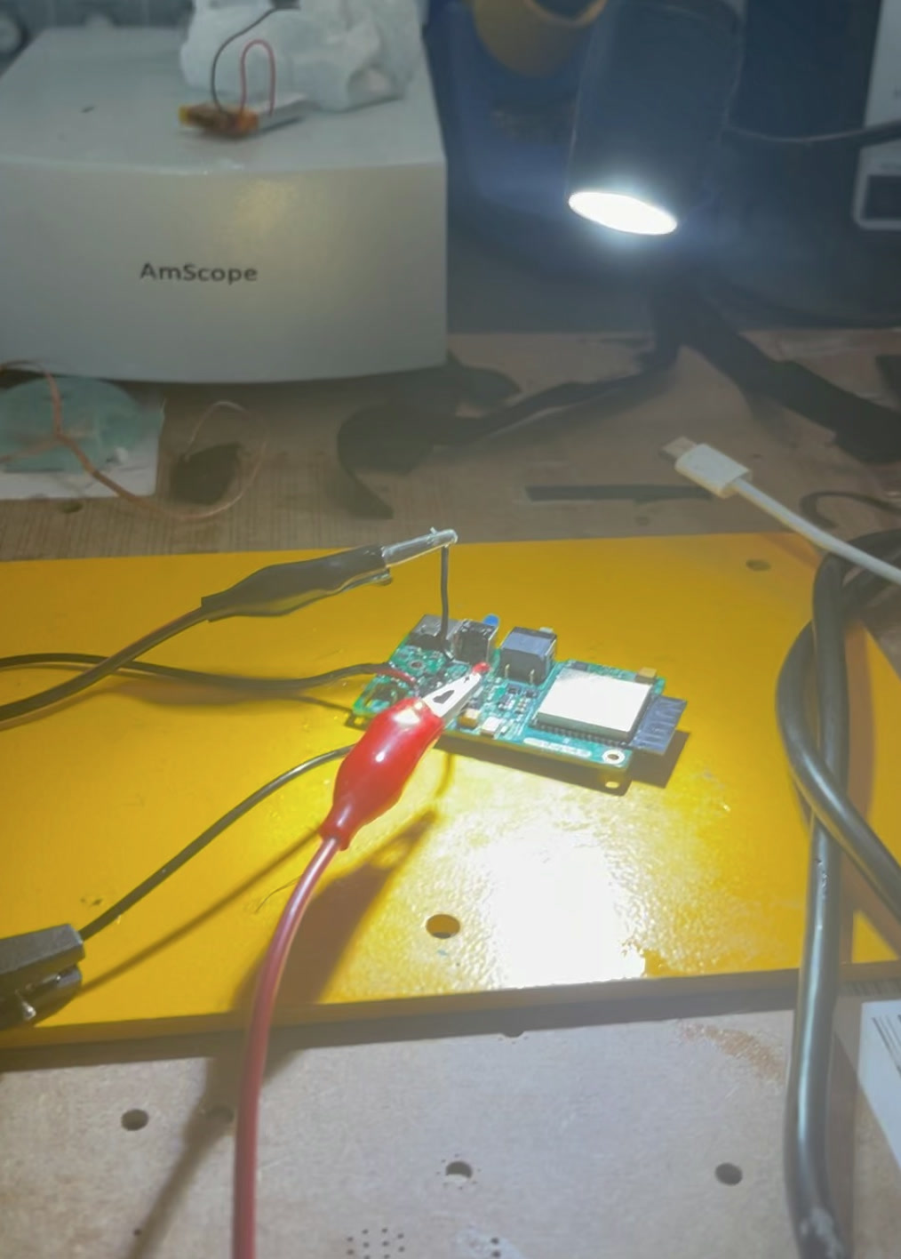 Development board undergoing electrical bring-up beneath a microscope
