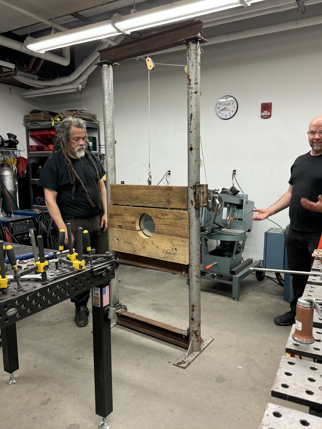 Two people demonstrating a large metal and timber shop fixture
