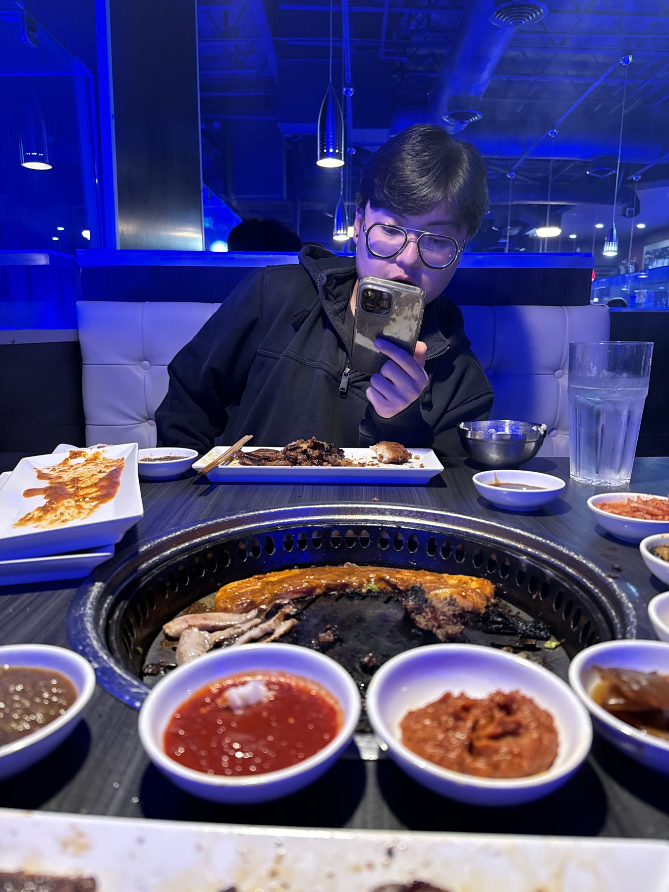 Friend seated across a Korean barbecue table