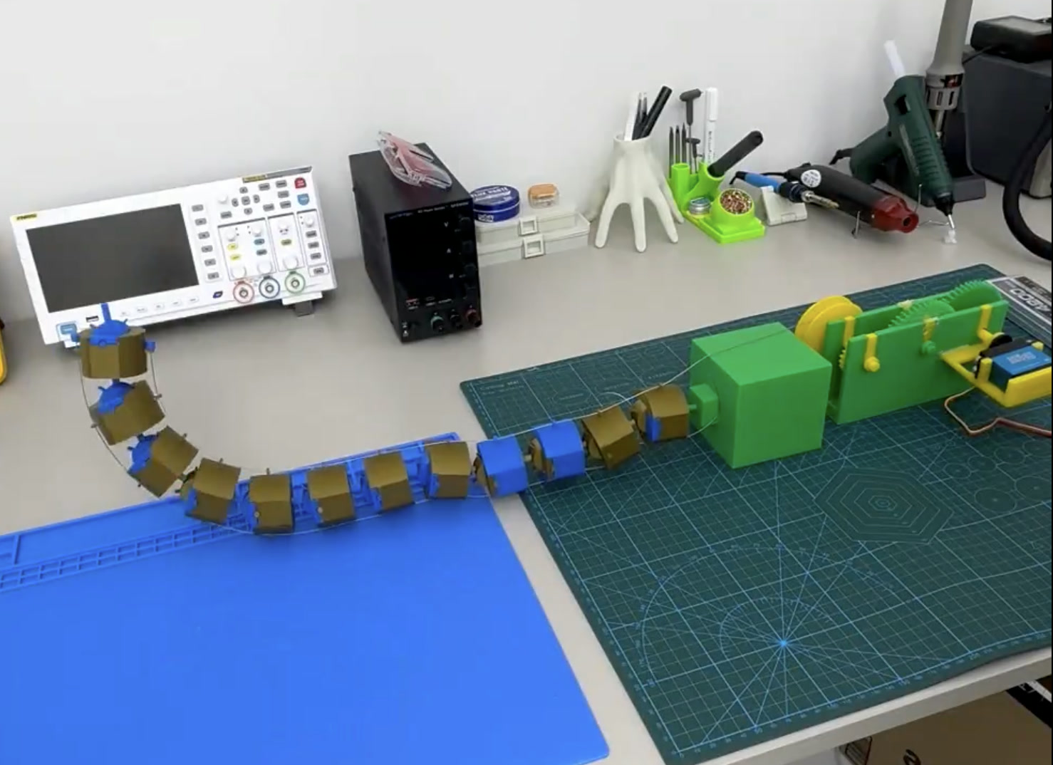 Segmented 3D-printed scorpion-tail mechanism on a workbench